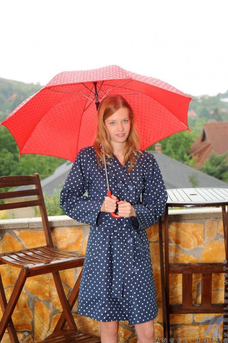 Улыбчивая малышка Angel Hott демонстрирует свою бритую киску и сиськи на воздухе под зонтом