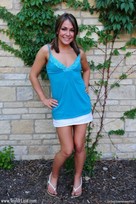 Милая брюнетка Taylor Lain снимает свою одежду в саду и показывает свою классную попку