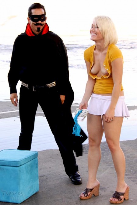 Человек в черном трахает дилдо обнаженную блондинку Ash Hollywood и заставляет ее согнуться на свежем воздухе